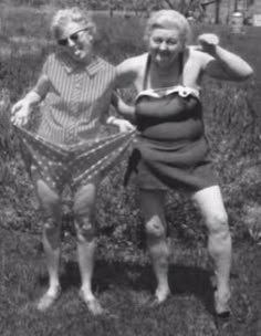 an old photo of two women standing in the grass