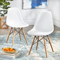 two white chairs sitting on top of a blue rug