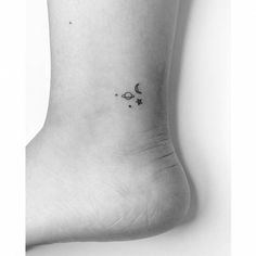 a black and white photo of a person's foot with the moon and stars on it