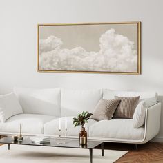 a living room with a couch, coffee table and painting on the wall above it