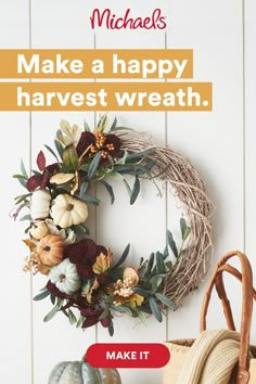 a wreath with flowers and leaves hanging on the wall next to a basket that says make a happy harvest