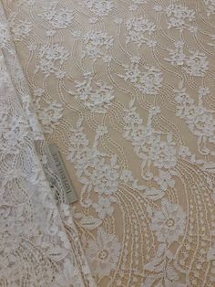 an image of white lace fabric with flowers on it