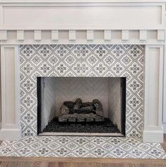 a white fireplace with black and white tile