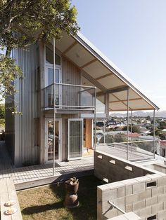 the house is made out of concrete and has a large deck on top of it