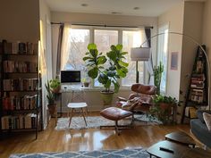 a living room filled with furniture and a large window covered in lots of windows next to a bookshelf