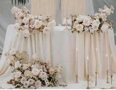 the table is set with flowers and candles for an elegant wedding reception or special event