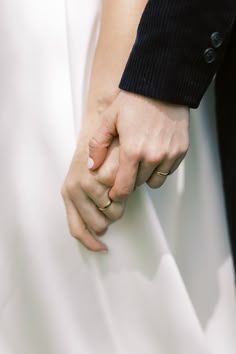 a close up of two people holding hands