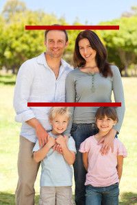 a man and woman standing next to two children in front of a red rectangle