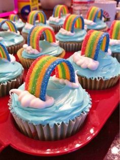 cupcakes with rainbow frosting and sprinkles are on a red plate