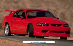 a red sports car driving down the road