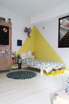 the room is decorated in yellow and white with an elephant head on the wall above the bed