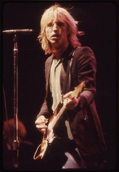 a man with blonde hair playing an electric guitar