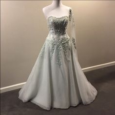 a dress on display in front of a white wall and grey carpeted flooring