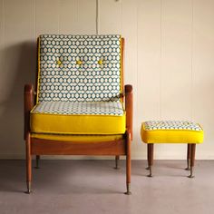 a yellow chair and footstool sitting next to each other in front of a white wall