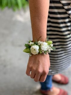 a close up of a person wearing a bracelet with flowers on it's wrist