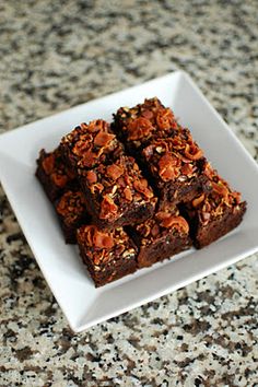 some brownies are on a white plate and is sitting on a granite countertop