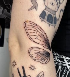 a close up of a person's arm with tattoos on it and an insect