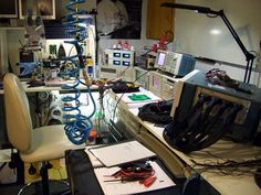 an office with many electronics and wires on the desk