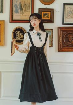 Striped crepe chiffon midi skirt with a lace-up elastic waist and suspender straps. Paired with a short sleeve blouse with pointed collar, cuffed sleeves and a removable matching neck tie. S: 36" chest, 24"-32" waist, 23" blouse length, 31" dress lengthM: 37.5" chest, 25.5"-33.5" waist, 23" blouse length, 31" dress lengthL: 39" chest, 27"-35" waist, 23" blouse length, 31" dress lengthXL: 40.5" chest, 28.5"-36.5" waist, 23" blouse length, 31" dress length Tie Neck Blouse Outfit, Housewife Outfit, Suspenders Skirt Outfits, Chiffon Midi Skirt, Skirt Outfit Fall, Suspender Skirt, Ladies Tops, Tops Fashion, Whimsical Fashion