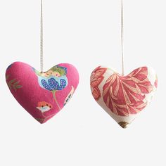 two heart shaped ornaments hanging from strings