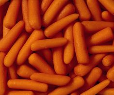 a pile of baby carrots that are orange