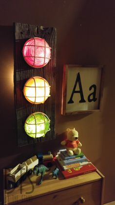 a wooden dresser topped with lots of toys next to a wall mounted sign that says aa