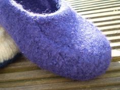 two slippers sitting on top of a wooden bench