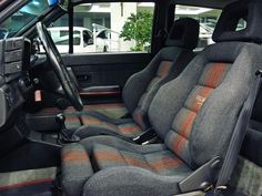 the interior of a vehicle with grey and orange seats