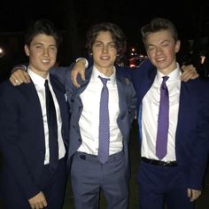 three young men in suits and ties posing for the camera