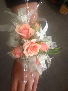 a woman's hand is holding a bouquet of flowers and pearls on it,