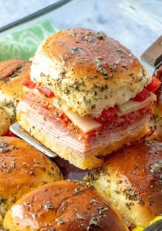 ham and cheese sliders stacked on top of each other with a knife in the middle