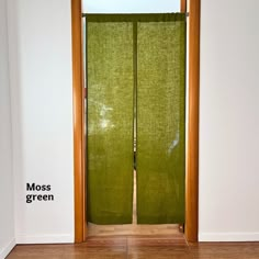 an open green door with the words moss green written on it in front of a white wall