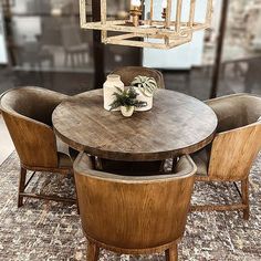 a wooden table with chairs around it and a chandelier hanging from the ceiling