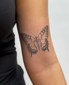 a woman's arm with a butterfly tattoo on the left side of her arm