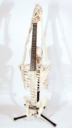 a skeleton sitting on top of a guitar