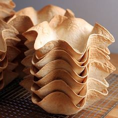 a stack of tortilla shells sitting on top of a wooden table