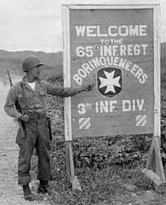 an old black and white photo of two men standing next to a sign