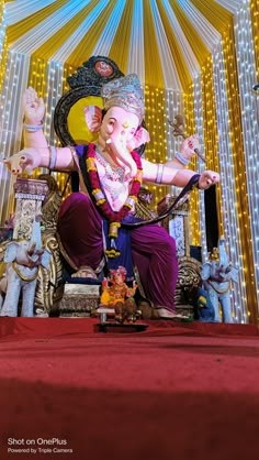 an elephant statue sitting on top of a red carpeted floor next to a stage