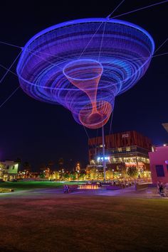 an illuminated object in the middle of a park at night