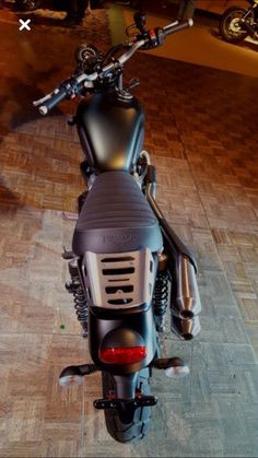 the motorcycle is parked on the wooden floor