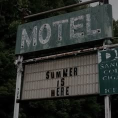 an old motel sign with the words summer is here on it's back side