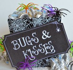 a sign that says bugs and koosies next to some candies with spider webs on them