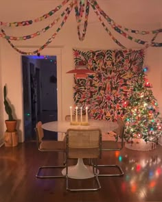 a decorated christmas tree in the corner of a living room with chairs and a table