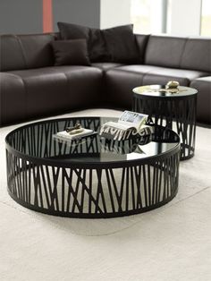 a black and white living room with two tables on each side of the coffee table