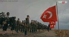 a group of men standing next to each other in front of a flag and horse