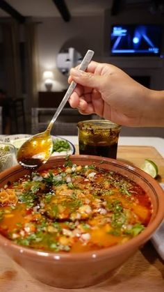 a bowl of soup is being spooned into it