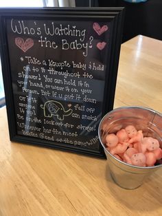 a metal bucket filled with baby potatoes next to a chalkboard sign that says who's watching the baby?