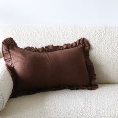 a brown pillow sitting on top of a white couch