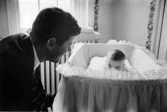 a man looking at a baby in a crib