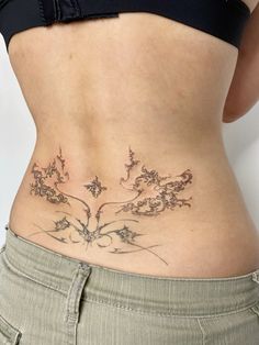 a woman's lower back tattoo with flowers on her stomach and the bottom part of her body